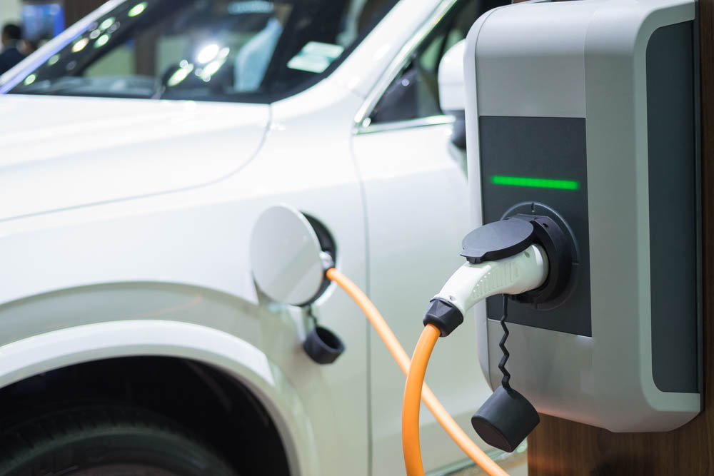 White car charging at an electric vehicle charging point