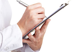 Hands holding a clipboard and pen representing a checklist