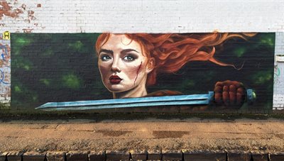 Mural of woman with long red hair and a sword