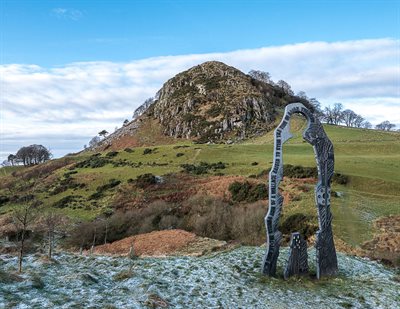 Spirit of Scotland sculpture to commemorate the historical significance of the Loudoun Hill area during the Scottish Wars of Independence. Loudoun Hill in the background which is a granite volcanic plug.