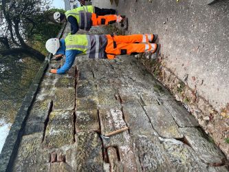 Two people in safety gear repairing an old church wall