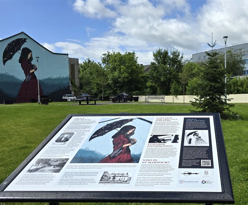 Information sign about the history of the Lady Ann Livingston Boyd Mural, and the mural in the background.