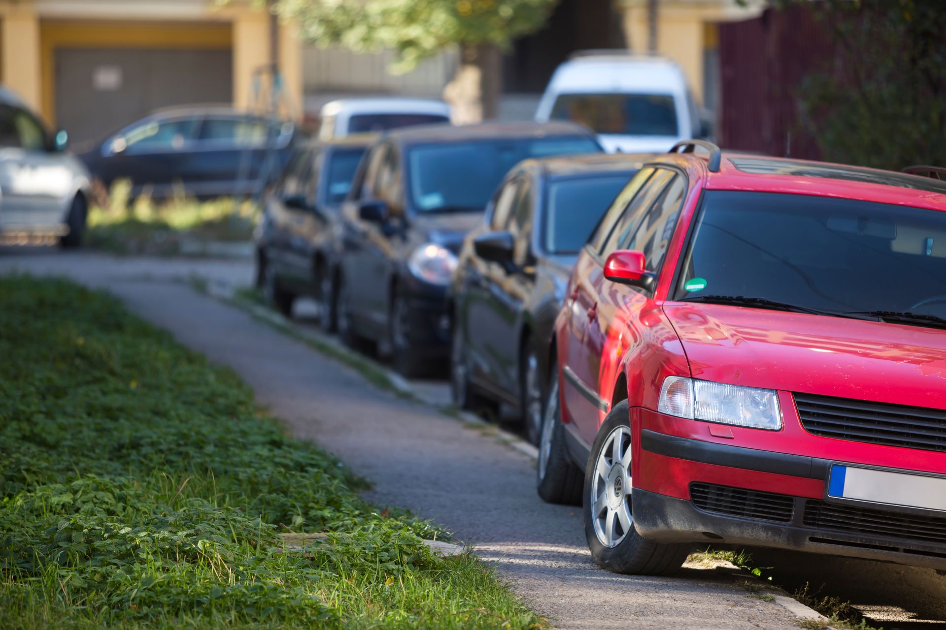 A red car parked on the pavement.
