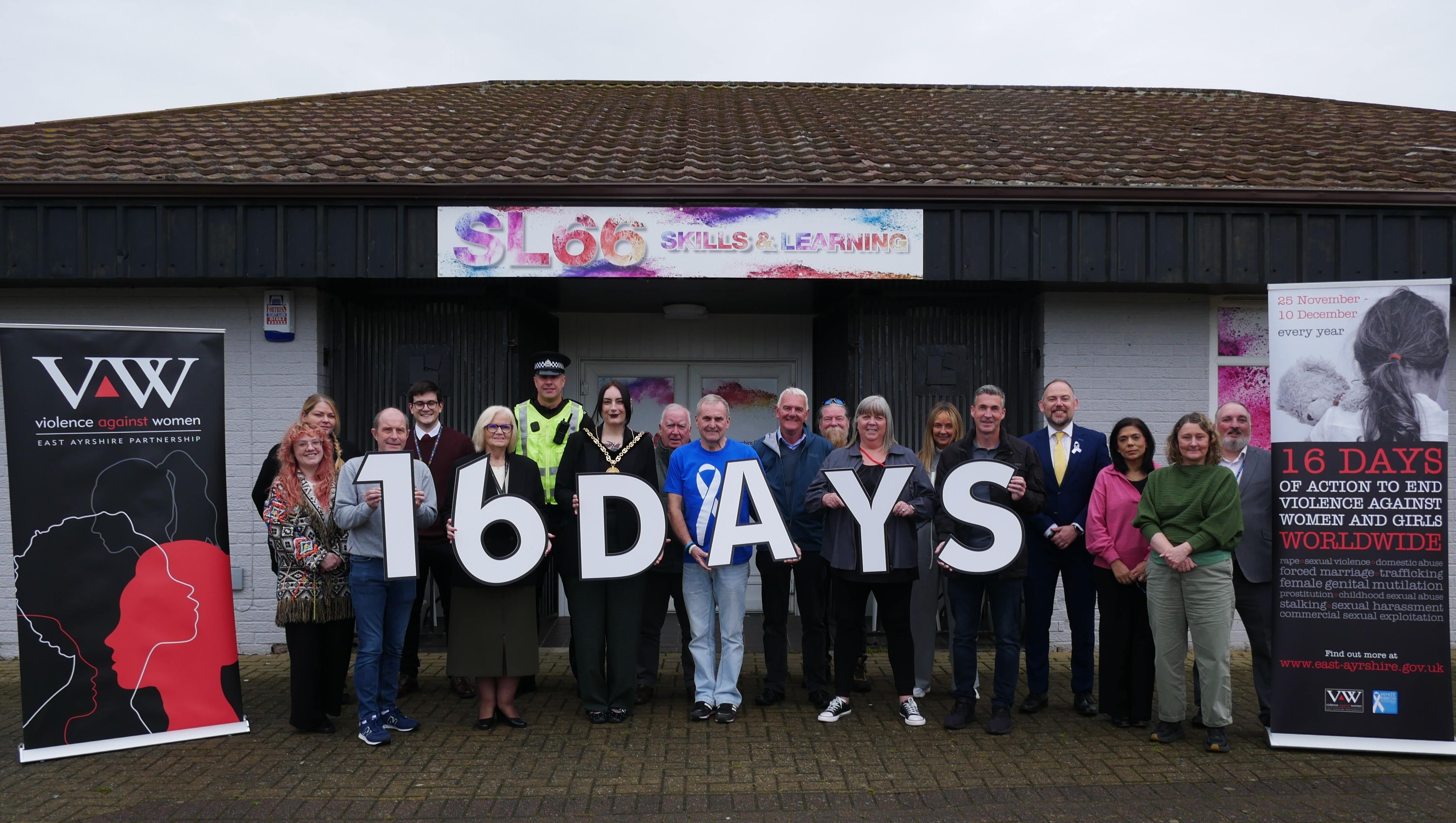 A group of people standing together holding numbers and letters saying 16 Days, supporting the 16 Days of Action campaign