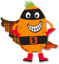 A smiling orange super tattie with green spikey hair, black eye mask, black belt with S on it, red gloves and boots and a tartan cape. Super Tattie is the Mascot for primary school meals in East Ayrshire.