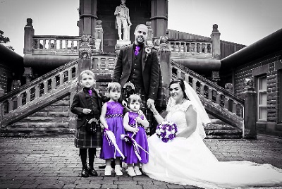 Bride and groom with children in the courtyard at the Burns Monument Centre, Robert Burns statue in the background