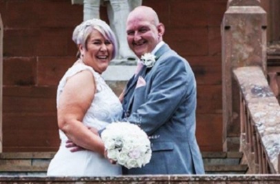 Bride and groom smiling, standing on the steps at the Burns Monument Centre