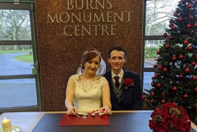 Bride and groom sitting at a table, smiling, at the Burns Monument Centre