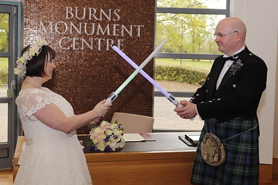 Bride and groom crossing lightsabers at the Burns Monument Centre