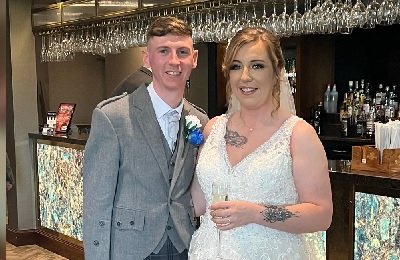 Bride and groom smiling, bar in the background