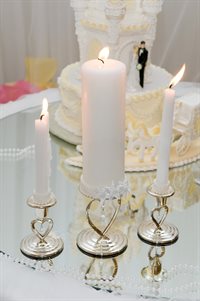 Three candles beside a wedding cake